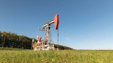 Operating oil and gas well in oil field profiled against the blue sky